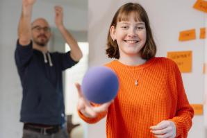 Mehrere Personen werfen Softball in Basketballkorb