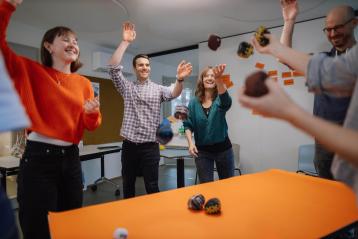 Viele Personen werfen Bälle in die Luft